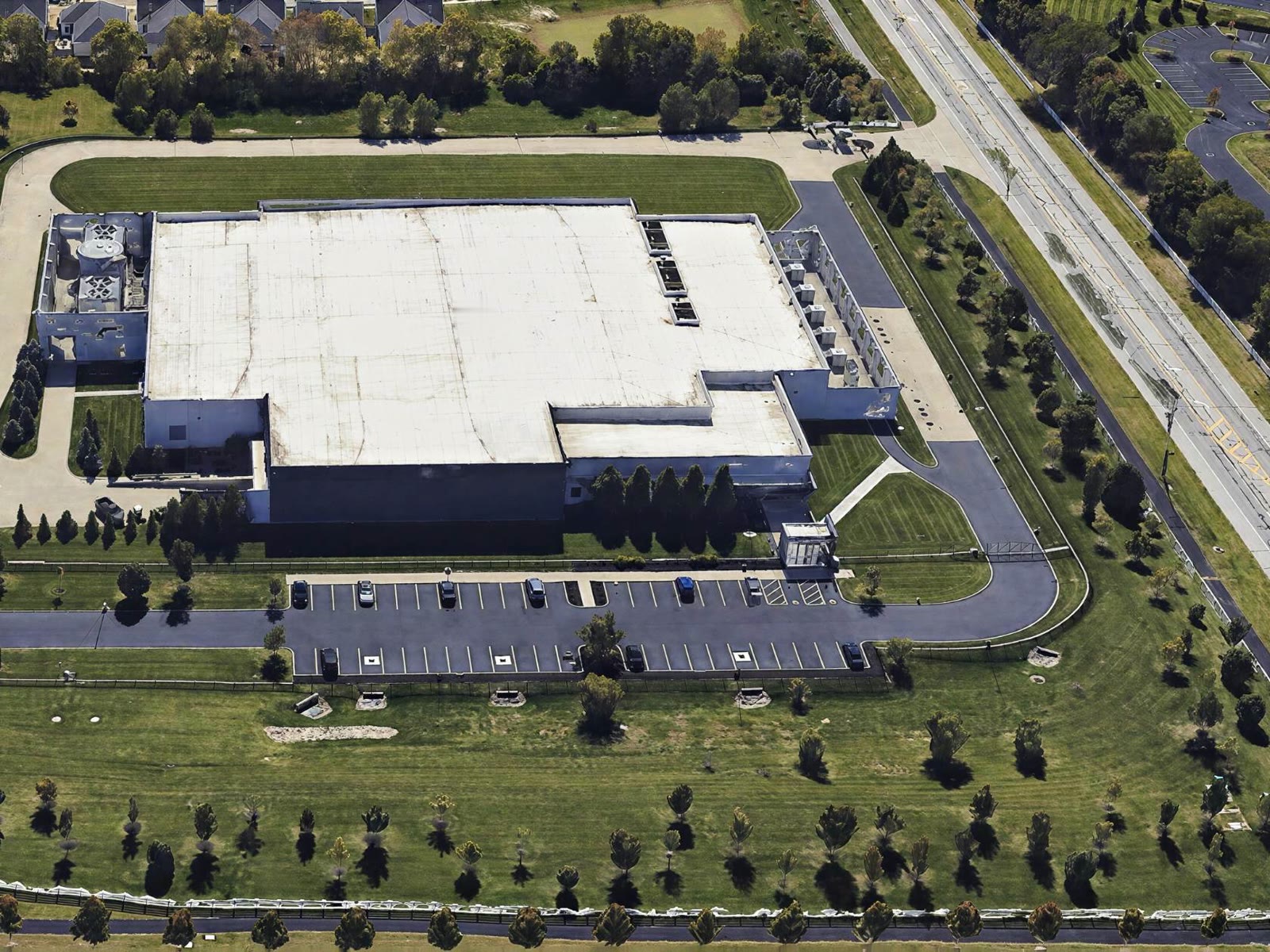 Aerial view of a 30 MW data center set among lawns and trees beside a highway